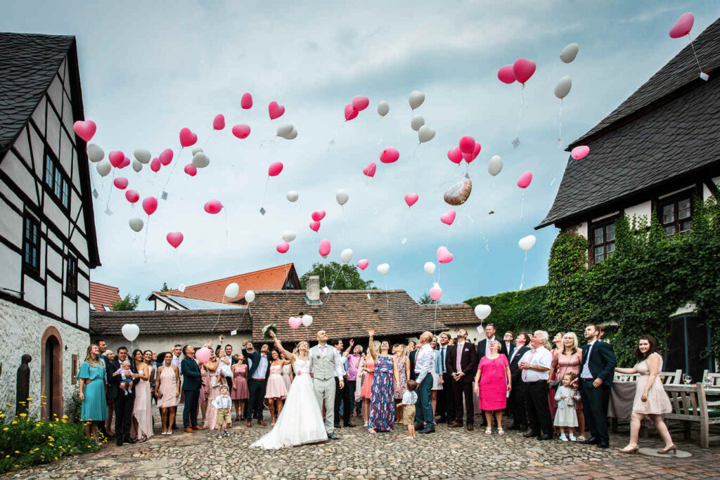 Skupina svatebčanů vypouší balónky.